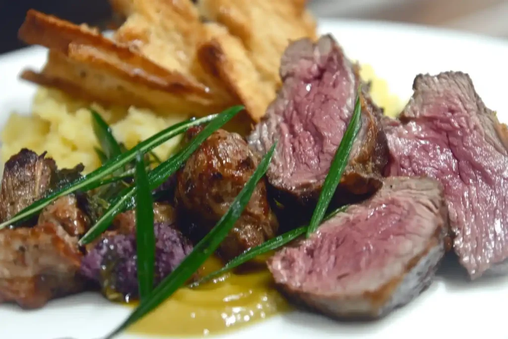 A photo of herb-crusted, wine-braised, and spicy venison roast variations, plated and garnished.